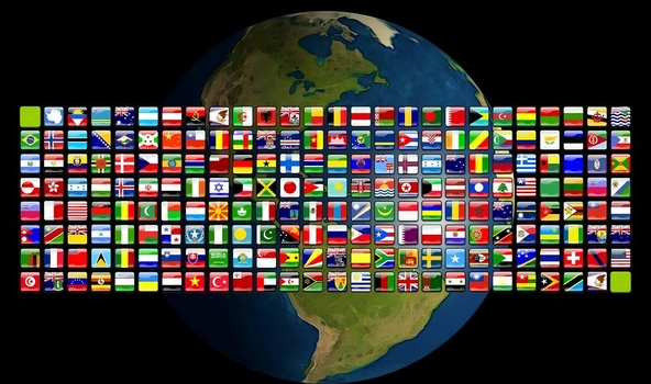 america-1313553_960_720_pixabay.jpg Im Hintergrund ist die Weltkugel. Davor sind in Form eines großen Rechtecks sehr viele kleine Flaggen von vielen Ländern der Erde.